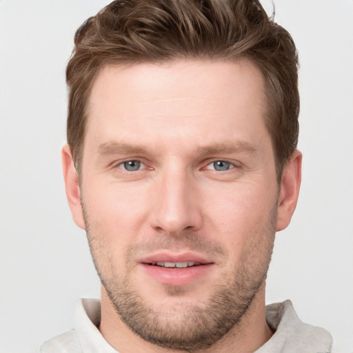 Joyful white young-adult male with short  brown hair and grey eyes