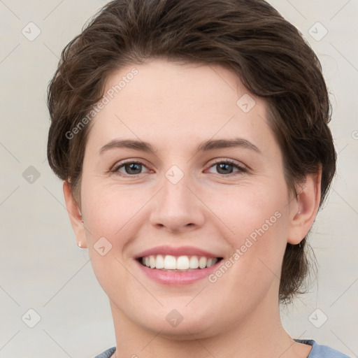 Joyful white young-adult female with short  brown hair and grey eyes