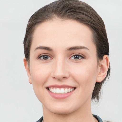 Joyful white young-adult female with short  brown hair and grey eyes