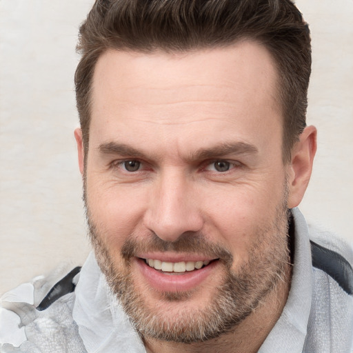 Joyful white adult male with short  brown hair and brown eyes