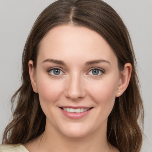 Joyful white young-adult female with long  brown hair and grey eyes