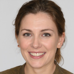 Joyful white young-adult female with medium  brown hair and grey eyes