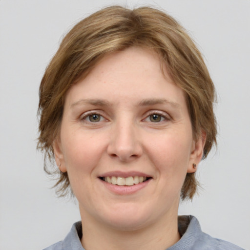 Joyful white young-adult female with medium  brown hair and grey eyes