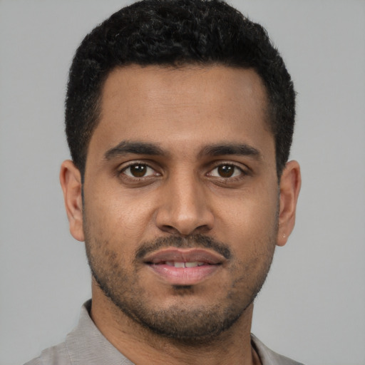 Joyful latino young-adult male with short  black hair and brown eyes
