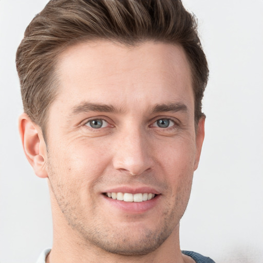 Joyful white young-adult male with short  brown hair and grey eyes