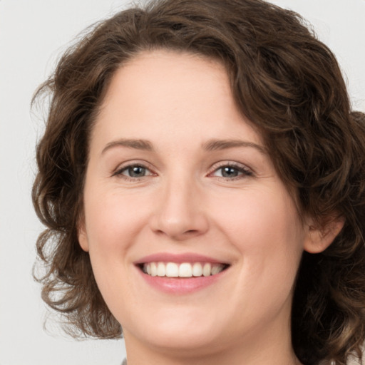 Joyful white young-adult female with medium  brown hair and green eyes