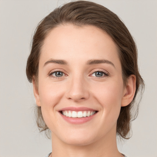 Joyful white young-adult female with medium  brown hair and green eyes