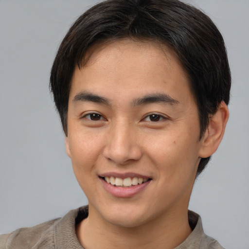 Joyful asian young-adult male with short  brown hair and brown eyes