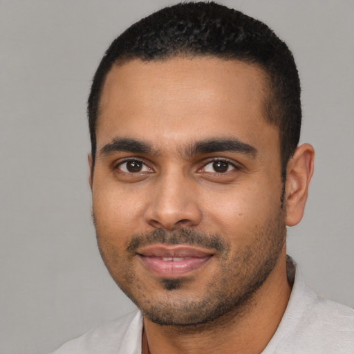 Joyful black young-adult male with short  black hair and brown eyes