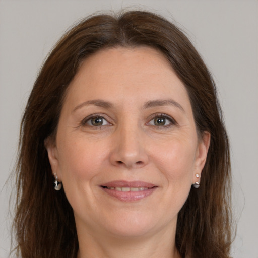 Joyful white adult female with long  brown hair and grey eyes