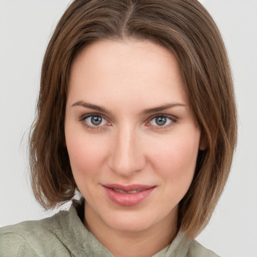 Joyful white young-adult female with medium  brown hair and green eyes