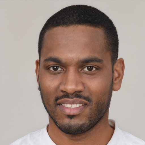 Joyful black young-adult male with short  black hair and brown eyes