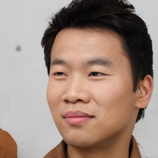 Joyful asian young-adult male with short  black hair and brown eyes