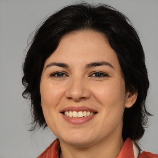 Joyful white adult female with medium  brown hair and brown eyes