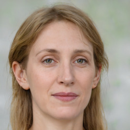 Joyful white adult female with long  brown hair and grey eyes