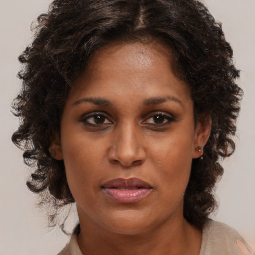 Joyful black adult female with medium  brown hair and brown eyes