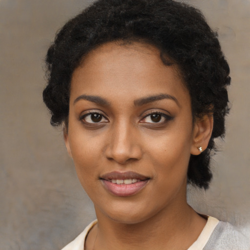 Joyful black young-adult female with short  black hair and brown eyes