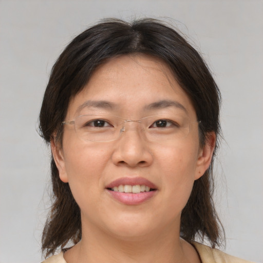Joyful asian adult female with medium  brown hair and brown eyes
