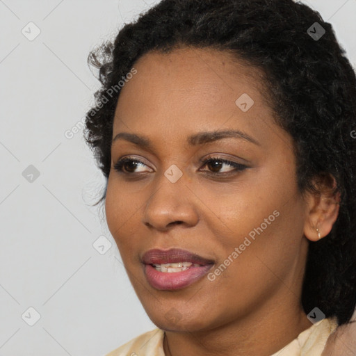 Joyful black young-adult female with long  black hair and brown eyes