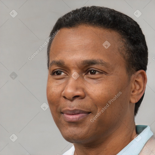 Joyful black adult male with short  black hair and brown eyes