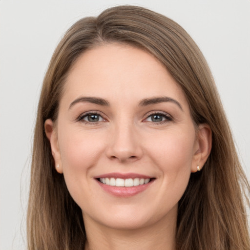 Joyful white young-adult female with long  brown hair and grey eyes