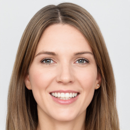 Joyful white young-adult female with long  brown hair and green eyes