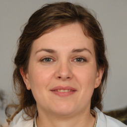 Joyful white adult female with medium  brown hair and blue eyes