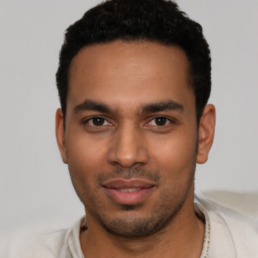 Joyful latino young-adult male with short  black hair and brown eyes