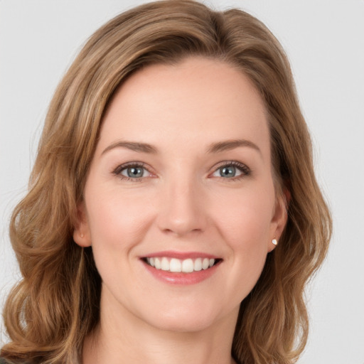 Joyful white young-adult female with long  brown hair and green eyes