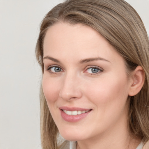 Joyful white young-adult female with long  brown hair and blue eyes