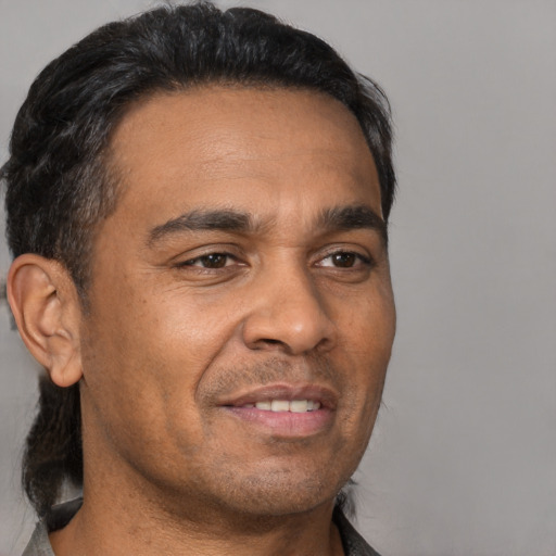 Joyful latino adult male with short  brown hair and brown eyes