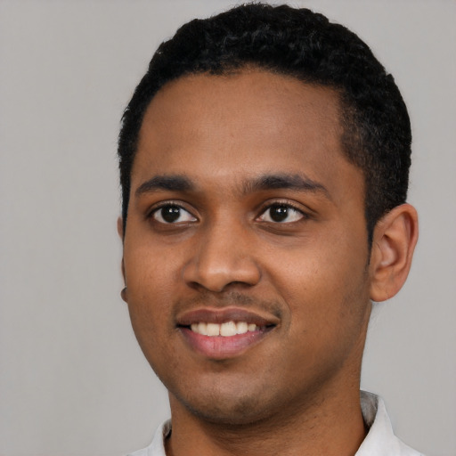 Joyful black young-adult male with short  black hair and brown eyes