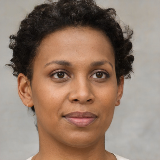 Joyful black young-adult female with short  brown hair and brown eyes