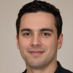 Joyful white young-adult male with short  black hair and brown eyes