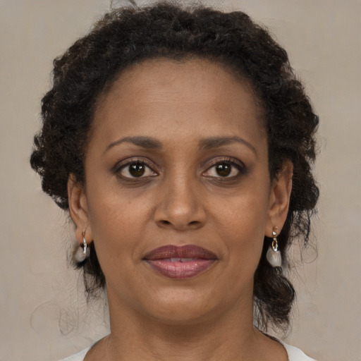 Joyful black adult female with medium  brown hair and brown eyes