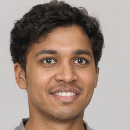 Joyful latino young-adult male with short  brown hair and brown eyes