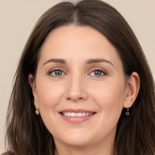 Joyful white young-adult female with long  brown hair and brown eyes