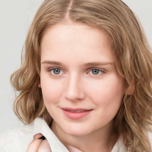 Joyful white young-adult female with medium  brown hair and blue eyes