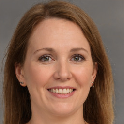 Joyful white adult female with long  brown hair and grey eyes