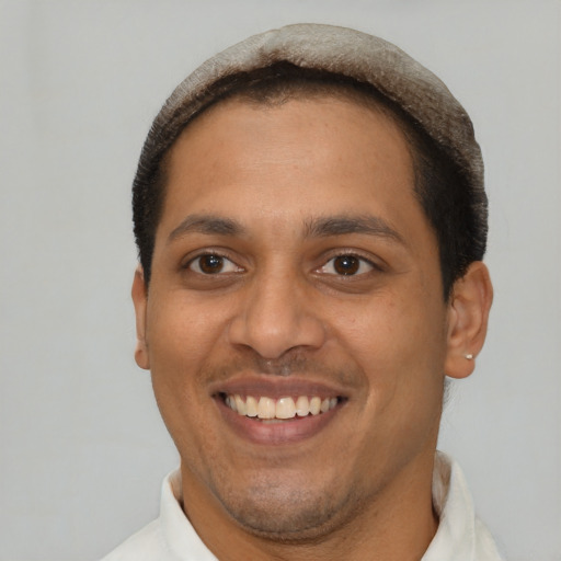Joyful latino young-adult male with short  brown hair and brown eyes