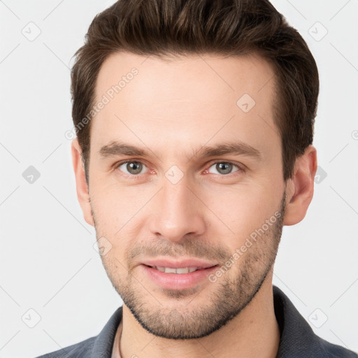 Joyful white young-adult male with short  brown hair and grey eyes