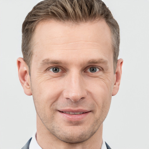 Joyful white adult male with short  brown hair and grey eyes