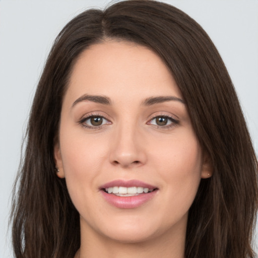 Joyful white young-adult female with long  brown hair and brown eyes