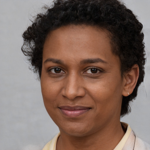 Joyful black adult female with short  brown hair and brown eyes
