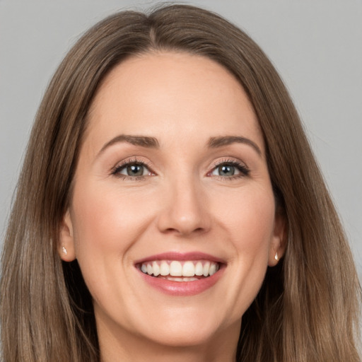 Joyful white young-adult female with long  brown hair and grey eyes