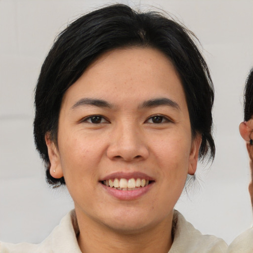 Joyful asian young-adult female with medium  brown hair and brown eyes