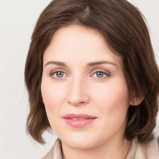 Joyful white young-adult female with medium  brown hair and green eyes