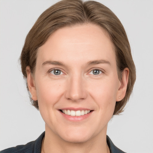 Joyful white adult female with medium  brown hair and grey eyes