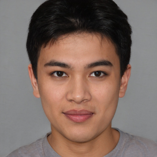 Joyful asian young-adult male with short  brown hair and brown eyes