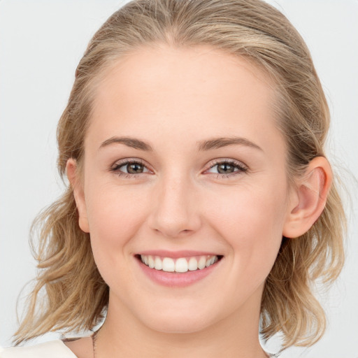 Joyful white young-adult female with medium  brown hair and blue eyes